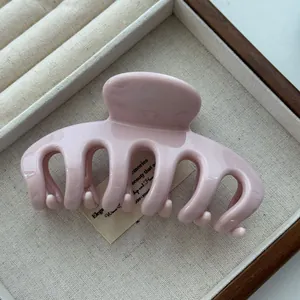 Detail of pink glossy dragon bone hair claw clip in a jewelry tray