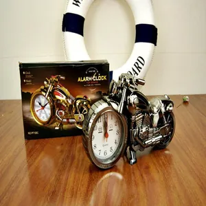 Detailed view of the vintage silver motorcycle-shaped alarm clock and its original gift box