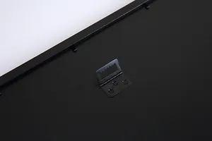 Macro detail of the sawtooth hanger on the back of a black scratch art picture frame
