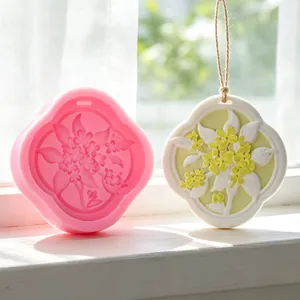 Silicone mold for floral wax tablets shown with a finished white aromatherapy pendant.