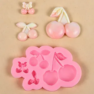 Detailweergave van kersensiliconenvorm met roze harsbedels op beige achtergrond.