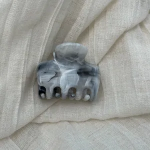 Grey marble ink pattern hair claw clip on soft textured linen background