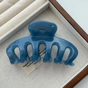 Close-up of minimalist blue dragon bone hair claw clip in elegant display box