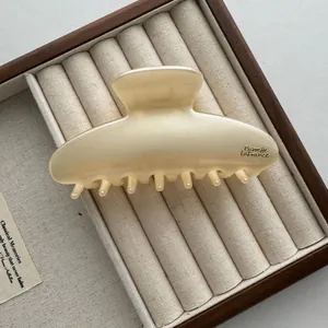 Gedetailleerd overzicht van een grote ivoorkleurige haarklem van 13 cm in vintage stijl
