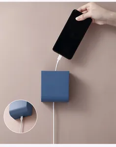 Blue wall-mounted storage box showing phone charging cable through the bottom hole