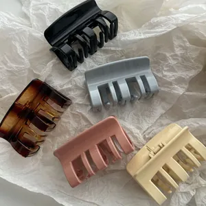 Vista detallada de cinco pinzas para el cabello de colores sobre fondo de papel arrugado