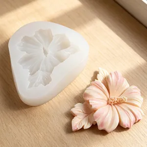 Detail view of a hibiscus flower silicone mold and the finished pink resin craft result