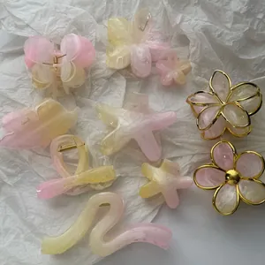 Collection of pink and yellow gradient floral and starfish shaped hair claw clips.
