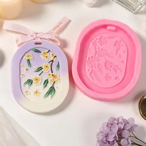 Dettaglio dello stampo in silicone floreale ovale e del ciondolo in gesso finito.