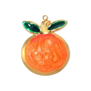 Detail view of a fruit shaped pendant with gold plating and vibrant orange enamel