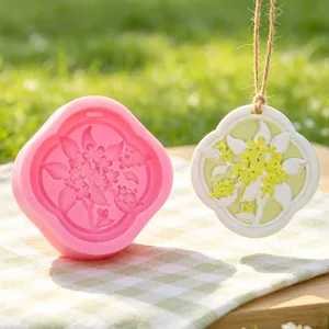 Macro detail of a pink floral silicone mold with its finished plaster pendant ornament