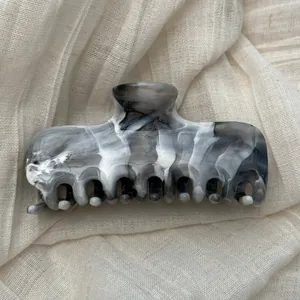 Detailed view of the elegant marble ink wash pattern on a large hair claw clip
