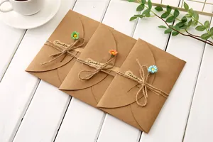 Close-up of vintage kraft paper greeting cards with handmade dried flowers and twine