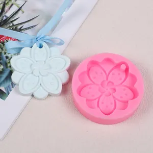 Détail du moule en silicone fleur de cerisier et un pendentif d'aromathérapie en plâtre