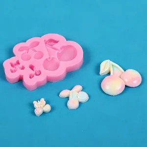 Gedetailleerde weergave van kersenvormige siliconen mal met afgewerkte pastel snoepjes