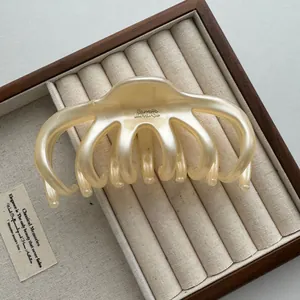 Elegante close-up van een 13 cm parelmoer crème haarklem in een luxe houten doos