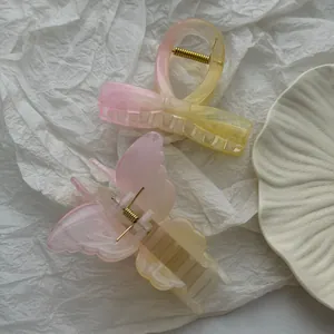 Detailed macro view of pink and yellow gradient butterfly and bow shaped hair claw clips