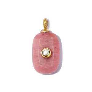 Detailopname van een ovale roze natuursteen hanger met kristal en goudkleurig oogje