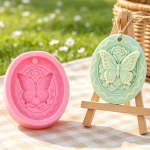 Detailed view of oval butterfly and rose silicone mold with finished plaster plaque