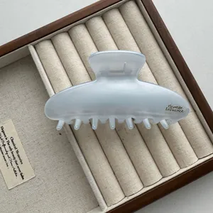 Detailopname van een grote 13 cm matblauwe haarklem in een houten sieradendoosje