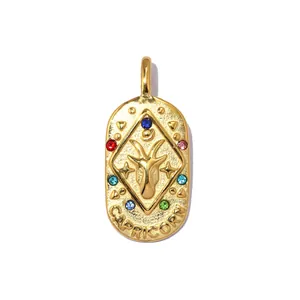 Vintage gold Capricorn zodiac pendant with colorful rhinestones on white background