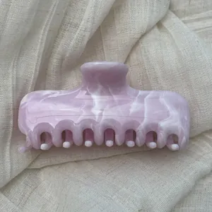 Detailed view of pink marble pattern on a French style hair claw clip with glossy finish