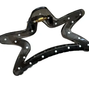 Black star-shaped hair claw clip with white polka dots for elegant bun hairstyles