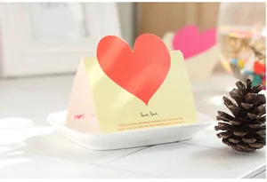 Primo piano dettagliato del biglietto di auguri a cuore con citazioni romantiche