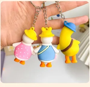 Set of three cute cartoon duck keychains featuring funny poses and colorful outfits.