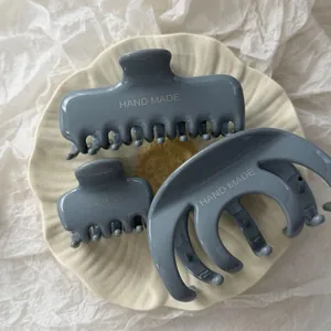 Dettaglio di un set di tre mollette per capelli minimaliste grigio-blu per doccia