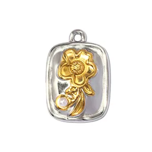 Detail view of a two-tone stainless steel flower pendant with a white pearl accent