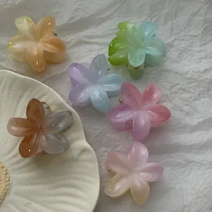 Plumeria bloem haarklemmen in gradiënt jelly kleuren op wit getextureerd papier