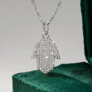 Κοντινή λήψη κολιέ με το χέρι της Φάτιμα και μωασσανίτη σε κομψό πράσινο βελούδο