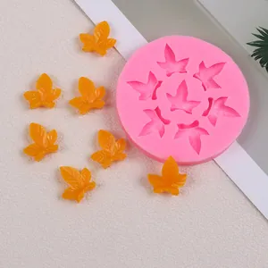 Détail d'un moule en silicone rose en forme de feuille d'érable avec des pièces en résine