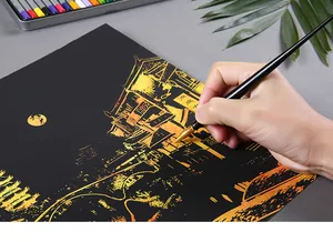 Mano che usa uno strumento per grattare su carta d'arte con scena notturna dorata