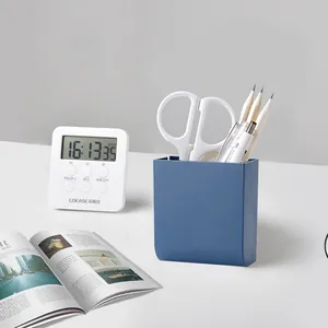Minimalist blue wall-mounted stationery storage box organizer on white office desk setup