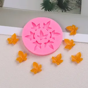 Vue rapprochée d'un moule en silicone rose avec des feuilles de fondant orange finies