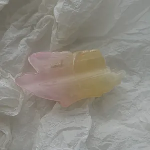 Detailed view of translucent pink and yellow gradient frangipani flower hair claw clip