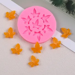 Moule en silicone feuille d'érable rose avec feuilles en résine jaune sur fond blanc