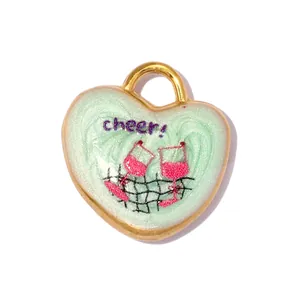 Close-up of a mint green heart pendant with wine glasses and cheer engraving