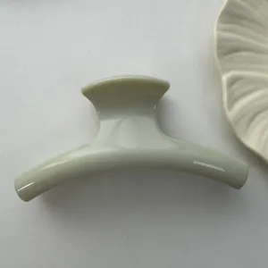 Detailed side view showing the smooth glossy finish of this large cream hair claw shark clip