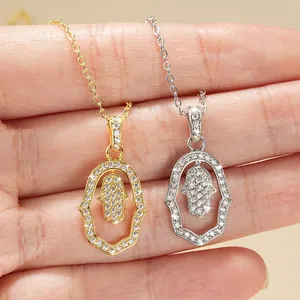 Detail of Hamsa Hand pendant necklaces in gold and silver with sparkling crystal inlay.