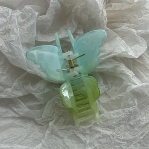 Dettaglio di un fermaglio per capelli a farfalla con sfumatura gelatina blu e verde