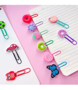 Detailed view of various colorful cartoon shaped paper clips set on a notebook page