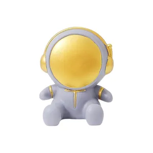 Minimalist astronaut phone holder for desk with golden helmet and grey body ornament