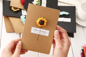 Detailed view of vintage kraft greeting card with 3D dried sunflower being held.