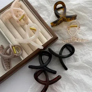 Assorted jelly-colored butterfly hair claw clips displayed on a wooden jewelry tray