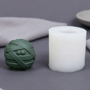 Detailed view of mummy ball silicone mold alongside a finished green wax sample
