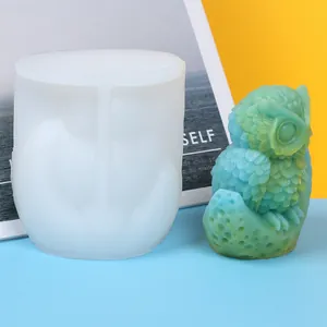 Detail view showing owl-shaped silicone mold next to finished teal owl candle.