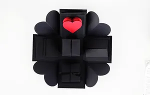 Vista superior de una caja de regalo DIY negra abierta con un corazón rojo